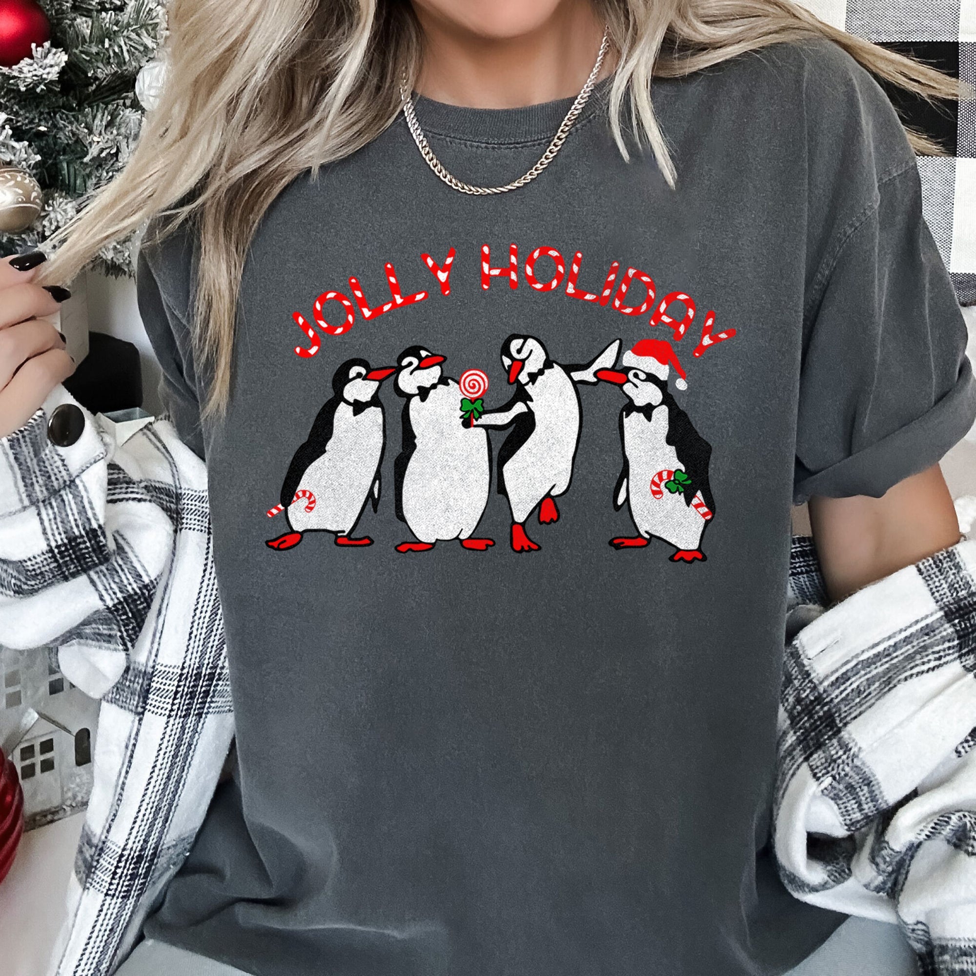 Jolly Holiday Penguins Christmas Parade In Cozy Winter Village Scene With Snowflakes And Cheer Comfort Colors Tee