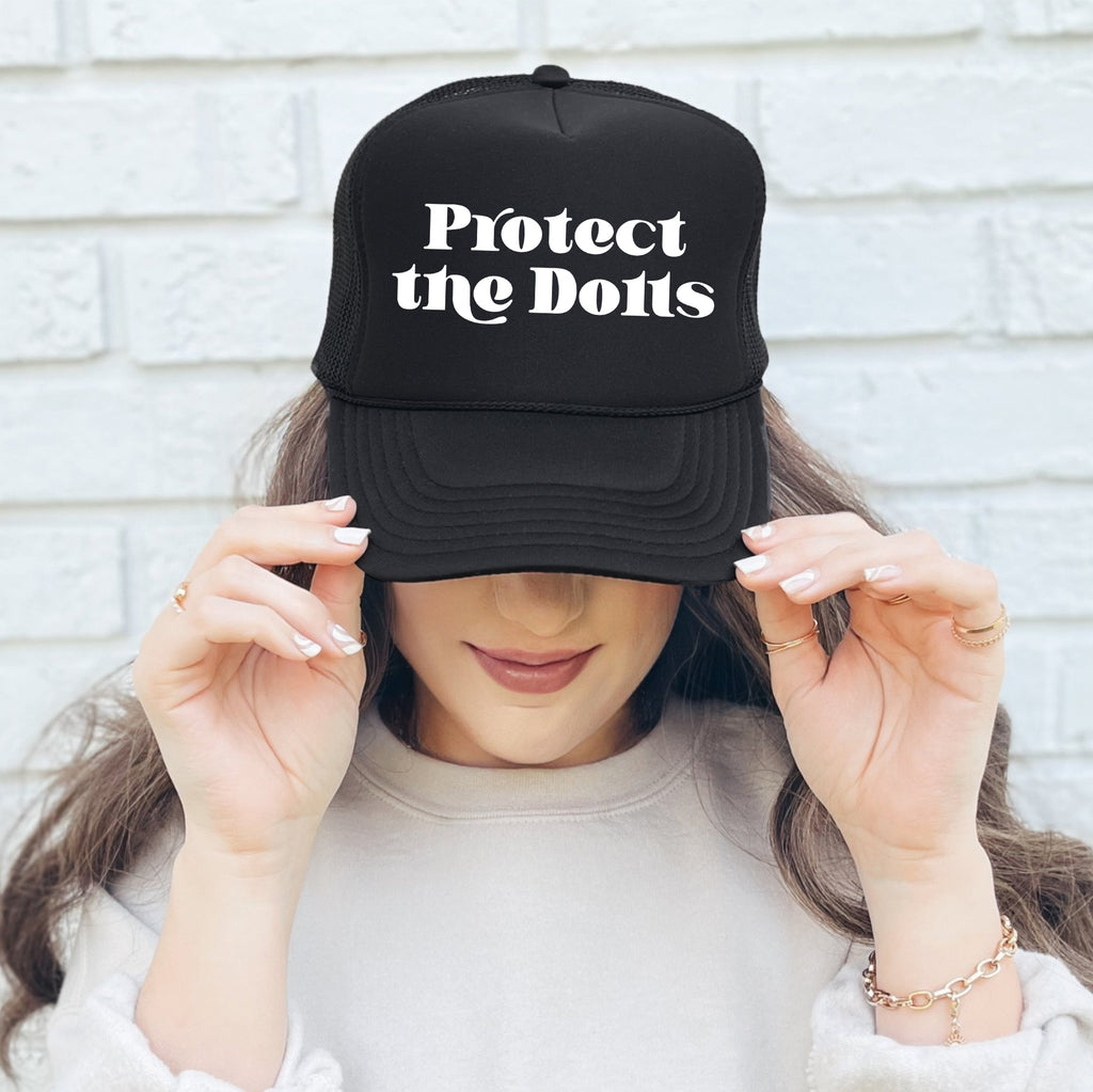 Protect The Dolls Bold Slogan Graphic For Real Talk Style Enthusiasts And Trendsetters Trucker Hat